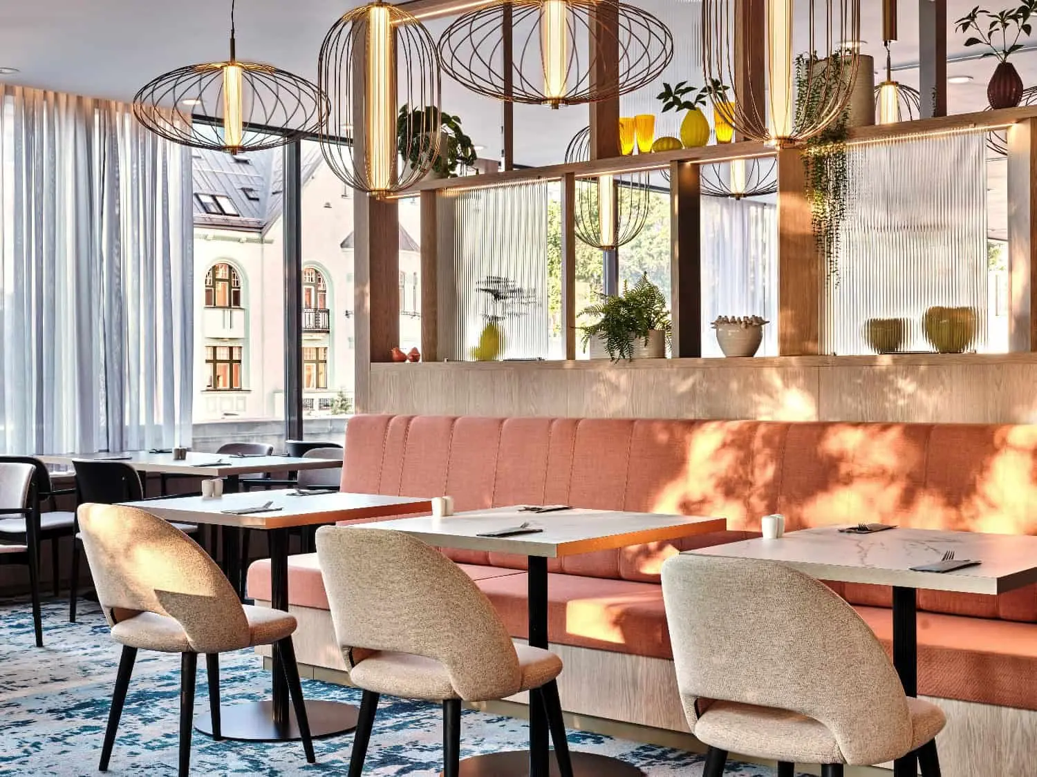 Reštaurácia Fresh! hotela Crowne Plaza Bratislava so záclonami, lososovým čalúnením a modrobielym kobercom
