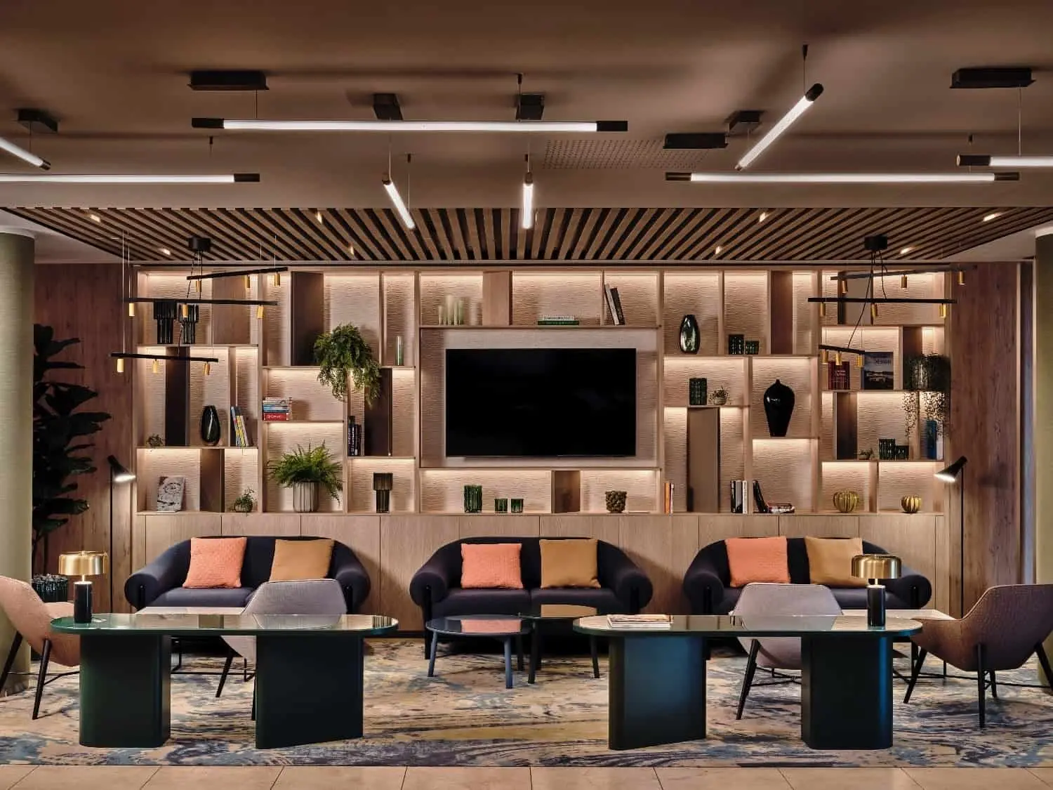 Lobby hotela Crowne Plaza Bratislava s tmavými pohovkami, farebnými vankúšmi a vzorovaným kobercom