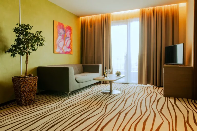 A pozsony-oroszvári Hotel Ponteo**** lakosztályának nappalija vonalmintás szőnyeggel, sötétítő- és fényáteresztő függönnyel